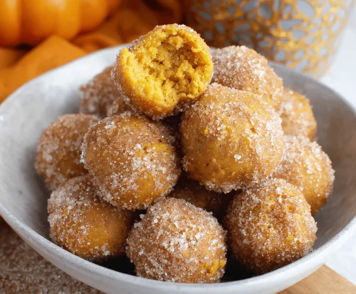 Delicious homemade Bisquick pumpkin donut holes on a white plate, perfect for fall treats and quick dessert recipes