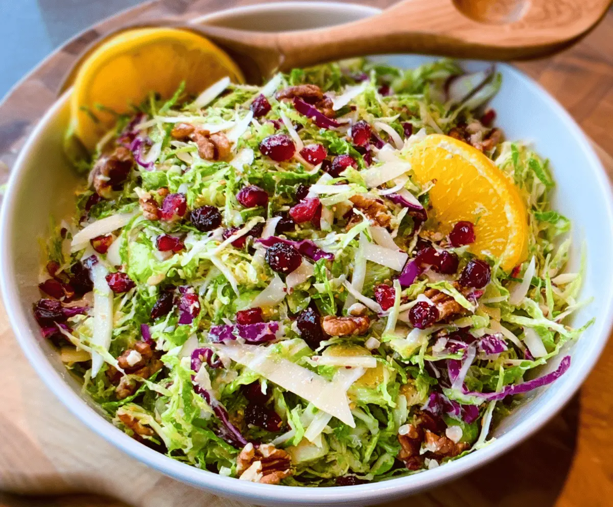 Fresh shaved Brussels sprouts salad decorated with lemon slices and herbs, healthy and colorful meal.