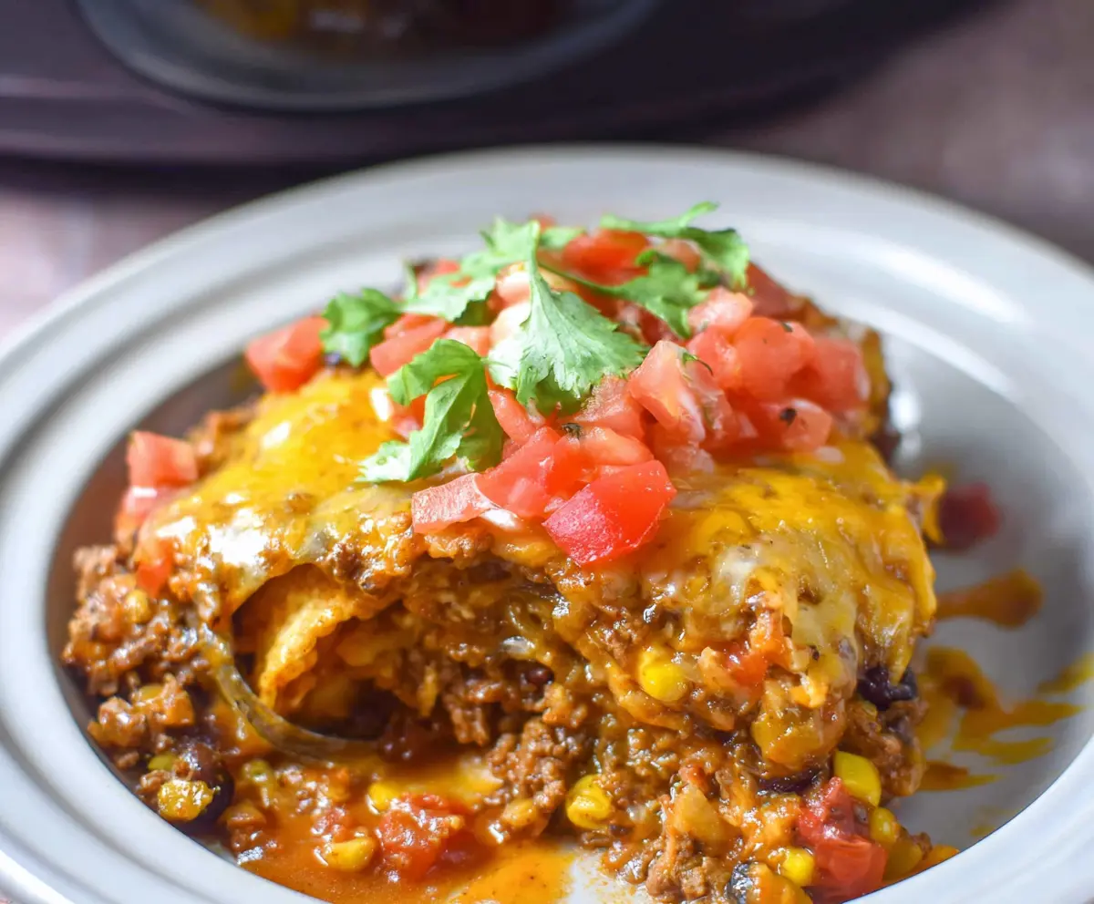 Delicious Crockpot Beef Enchilada Casserole topped with melted cheese and fresh toppings