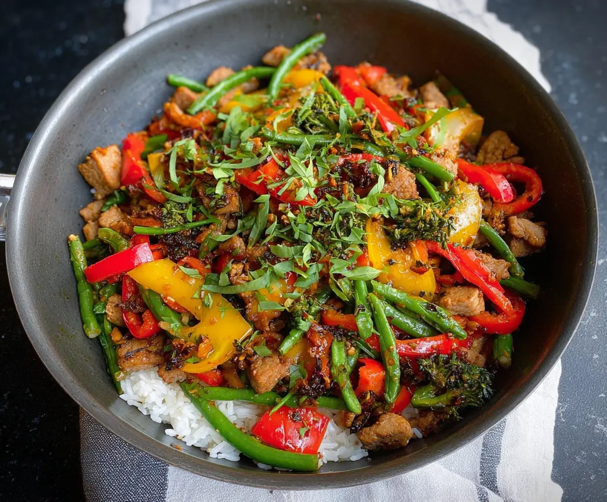 Delicious garlic pork stir fry with tender slices of pork and fresh vegetables on a wok.